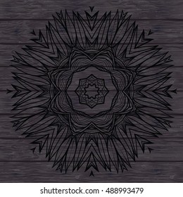 Black outline mandala. Mandala on the wooden background.