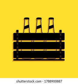 Black Pack of beer bottles icon isolated on yellow background. Wooden box and beer bottles. Case crate beer box sign. Long shadow style. Vector.