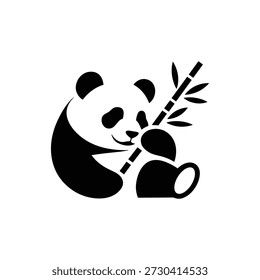 Black panda bear holding bamboo stalk