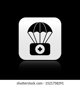 Black Parachute with first aid kit icon isolated on black background. Medical insurance. Silver square button. Vector Illustration
