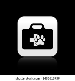 Black Pet first aid kit icon isolated on black background. Dog or cat paw print. Clinic box. Silver square button. Vector Illustration