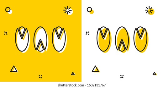 Black Pistachio nuts icon isolated on yellow and white background. Random dynamic shapes. Vector Illustration