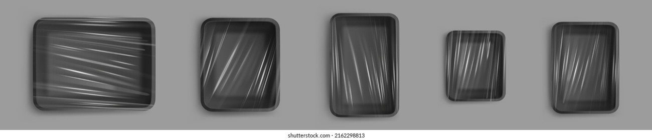 Black plastic trays for food, empty styrofoam containers with transparent film wrapper. Vector realistic mockup of 3d polystyrene package for lunch, meal and fresh products