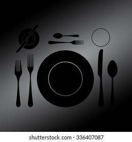 Black plate with spoon, knife and fork 