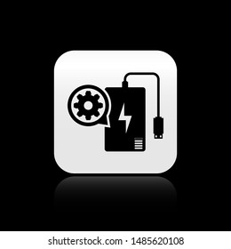 Black Power bank with charge cable and gear icon isolated on black background. Adjusting app, service concept, setting options, maintenance, repair. Silver square button. Vector Illustration