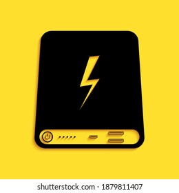 Black Power bank icon isolated on yellow background. Portable charging device. Long shadow style. Vector.