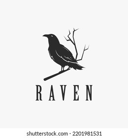 Black raven logo hanging on dead tree branch design vector on white background