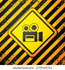 Black Retro cinema camera icon isolated on yellow background. Video camera. Movie sign. Film projector. Warning sign. Vector