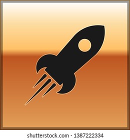 Black Rocket ship with fire icon isolated on gold background. Space travel. Vector Illustration