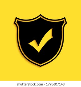 Black Shield with check mark icon isolated on yellow background. Long shadow style. Vector.