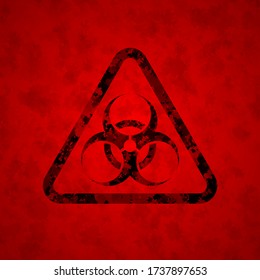 The black sign is a biological danger against a dirty red background. The structure of the sign is damaged. Spots on the sign and in the background