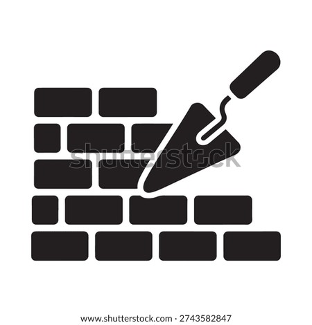 Black silhouette of a brick wall with a trowel applying mortar
