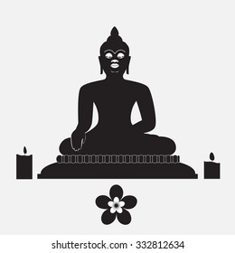 Black silhouette of Buddha with candle and flower