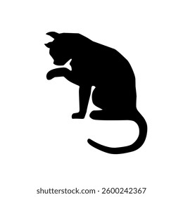 Black silhouette of a cat licking its hand