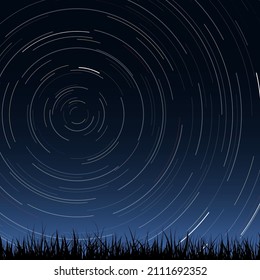 Black silhouette of grass under the night sky with a lot of stars trails. Blue dark night sky with stars moving across the polar pole in the sky. Photographic effect with time lapse.