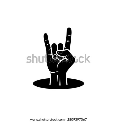 Black silhouette of a hand showing the rock and roll sign with index and pinky fingers raised, appearing from a hole