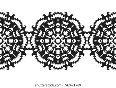 Black silhouette of a snowflake. Lace, round ornament and decor.