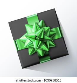 Black small square gift box with big glittering green bow and ribbons isolated on white background. Top view. Vector realistic festive illustration. Decoration element for holiday design.