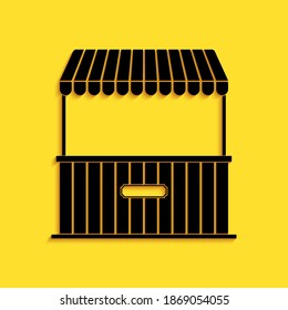 Black Street stall with awning and wooden rack icon isolated on yellow background. Kiosk with wooden rack. Long shadow style. Vector.