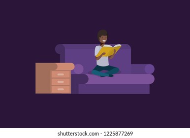 black student sitting reading book in livingroom