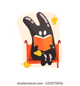 Black Tar Jelly Rabbit Shape Monster Reading A Book On The Bench Under Falling Yellow Leaves Outdoors In Autumn Season