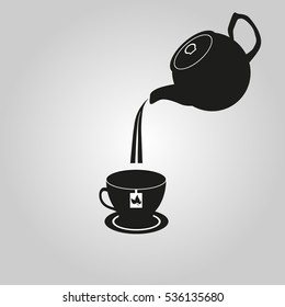 black teapot with a cup on a gray background