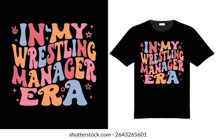 Uma camiseta preta mostra um texto colorido retro-estilo gráfico "In My Wrestling Manager Era" com letras pastel rosa, laranja e azul. 