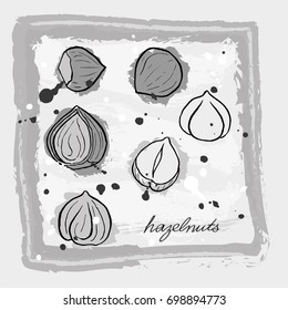 A black and white card with hand drawn hazelnut in grayish tones on grunge background