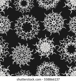 Black and white geometrical vector seamless pattern with ethnic mandalas or snowflakes.