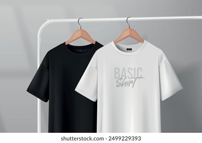 Black and white t-shirts hanging on a clothes rack in a studio on a wooden hanger.