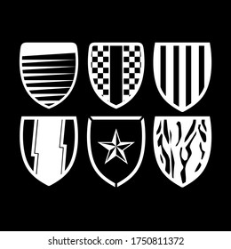 Black white vector illustration of a set shields icons, isolated on a black background.