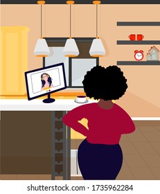 A black woman in the kitchen is working and preparing food. Home office interior. The concept of remote work. Freelance. Audio books and online conferencing.