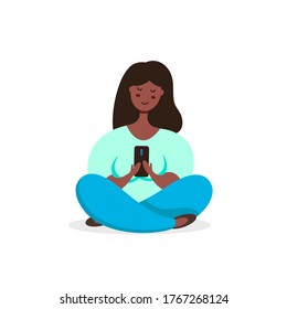 Black woman meditating in lotus pose uses smartphone. Vector illustration in flat style.