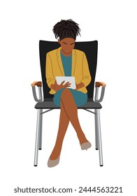 Black woman sitting, working on digital tablet.