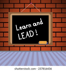 Blackboard with the text learn and lead written with chalk