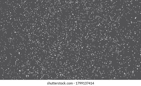 Blacktop surface texture. Small white spots of irregular shape on a dark gray background.