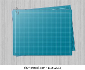 Blank blueprint paper with one sheet of the same paper underneath and joined with the paperclip. Both blueprints are laid on the grey metal lookalike background...