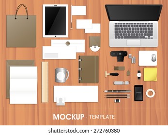 Blank corporate identity kit including Letterhead, File Folder, Laptop, Tablet PC, Visiting Cards, Envelopes, Smartphone and Stationery on wooden background. 