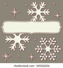Blank frame with paper cut snowflakes over vintage brown background.