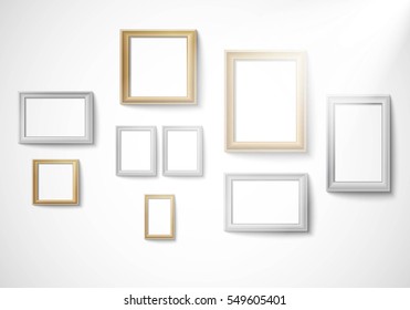 Blank gold and silver picture frame template isolated on wall with light