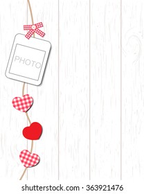 Blank instant photo and small red paper heart hanging on the clothesline