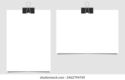 Leeres Papierblatt im A4-Format mit schwarzem Binder-Clip auf grauem Hintergrund. Vorlage des Dokuments. Flache Farben