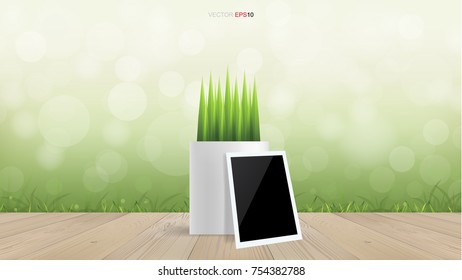 Blank photo frame and flower pot on wooden terrace with light blurred bokeh of green natural area background. Vector illustration.