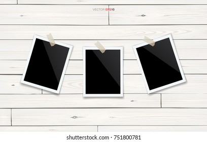 Blank photo frame or picture frame stick on white wooden wall. Vector vintage background.