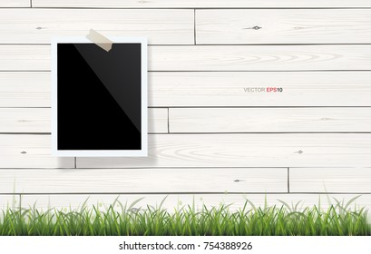 Blank photo frame or picture frame stick on vintage wooden texture background and green grass. Vector illustration.