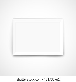 Blank picture frame on a bright wall. Template for a content