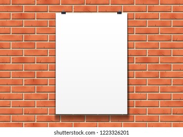 Blank poster mockup on the paper clips in front of red brick wall in bright loft room