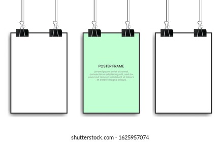 Blank posters hanging with binder clips.