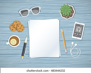 Blank sheets of paper on the desktop. Top view of paper, pen, pencil, smartphone running the music player, headphones, sunglasses, tea with lemon,cookies. Preparation for work, notes, sketches.