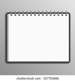 Blank spiral notebook on white background with soft shadows. 
